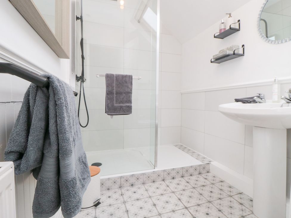 A bathroom with a shower and sink at Minn's Cottage in Snainton