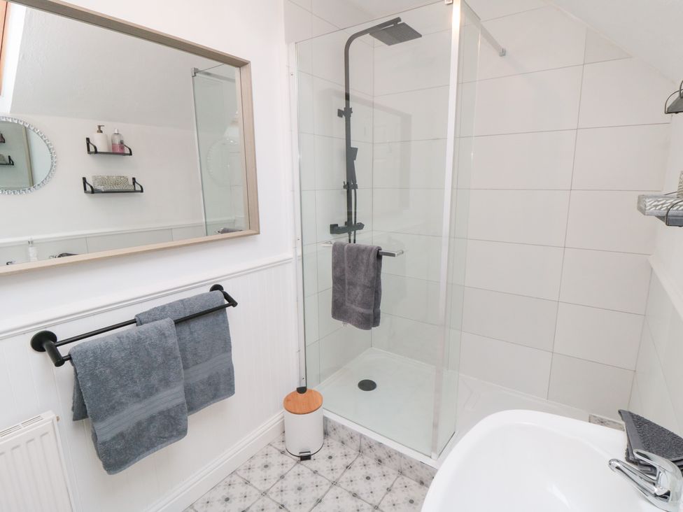 A bathroom with a shower and bathtub at Minn's Cottage in Snainton