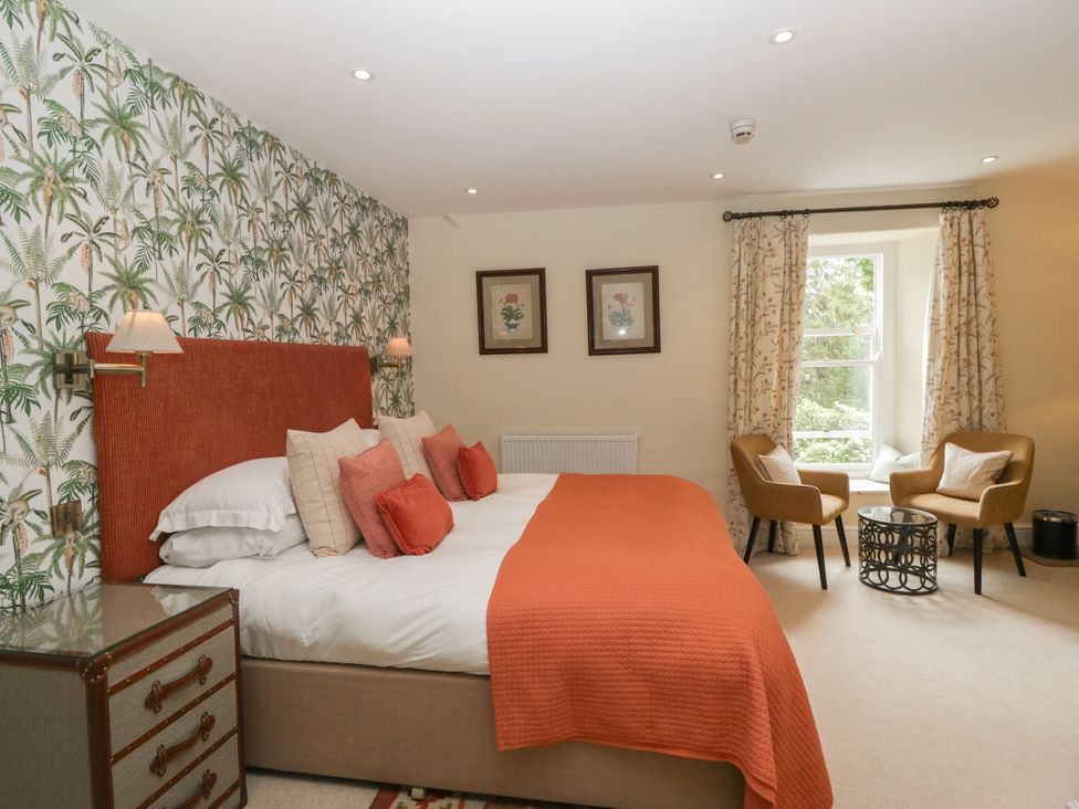 A bedroom with a bed and armchairs at Shelley in Ambleside