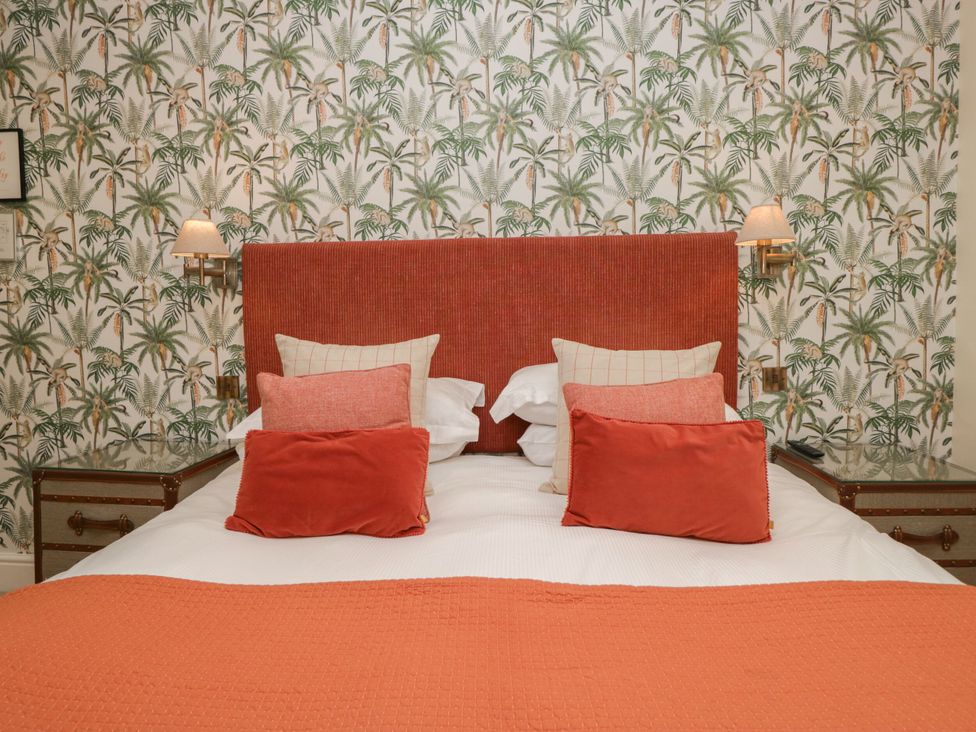 A bedroom with a bed and patterned wallpaper at Shelley in Ambleside