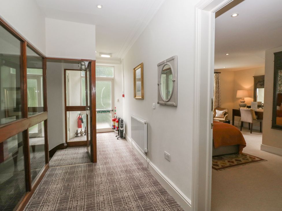 A hallway with a mirror and fire extinguisher at Shelley in Ambleside