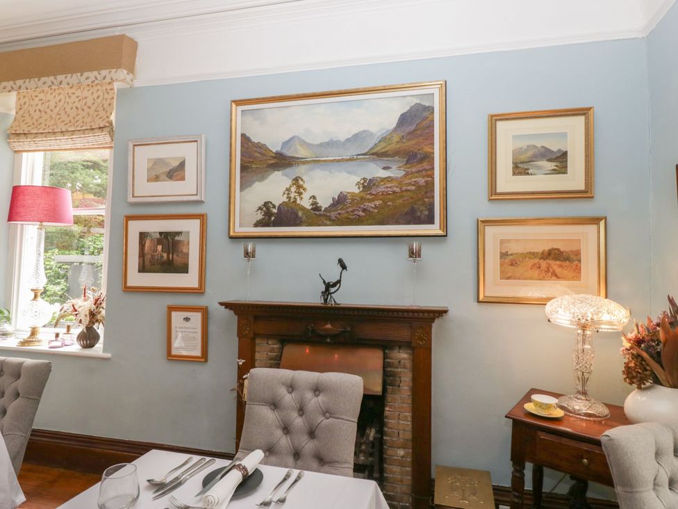 A dining room with a fireplace and artwork at Shelley in Ambleside