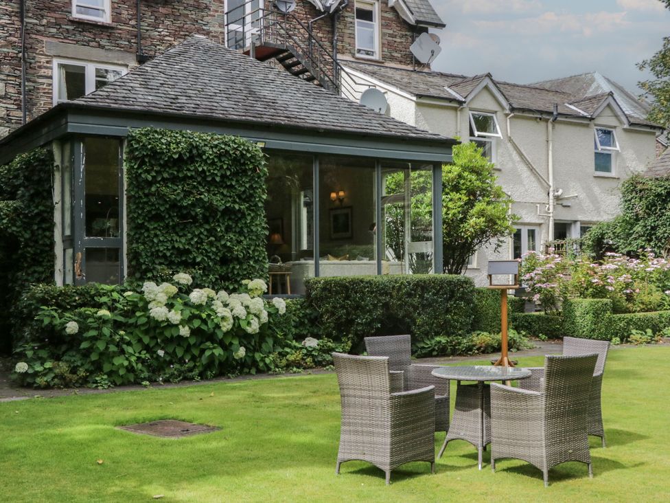 A garden with a glass house and seating at Shelley in Ambleside