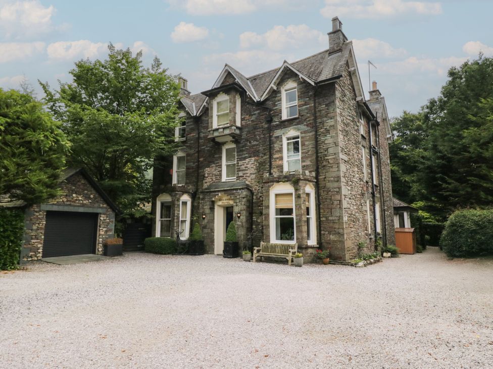 A house with a garage and trees at Coleridge in Ambleside
