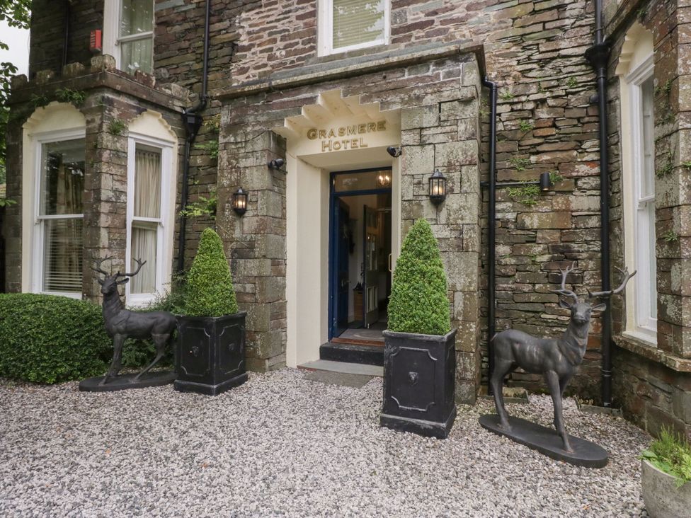 The entrance of Grasmere Hotel with deer statues and topiary in Ambleside