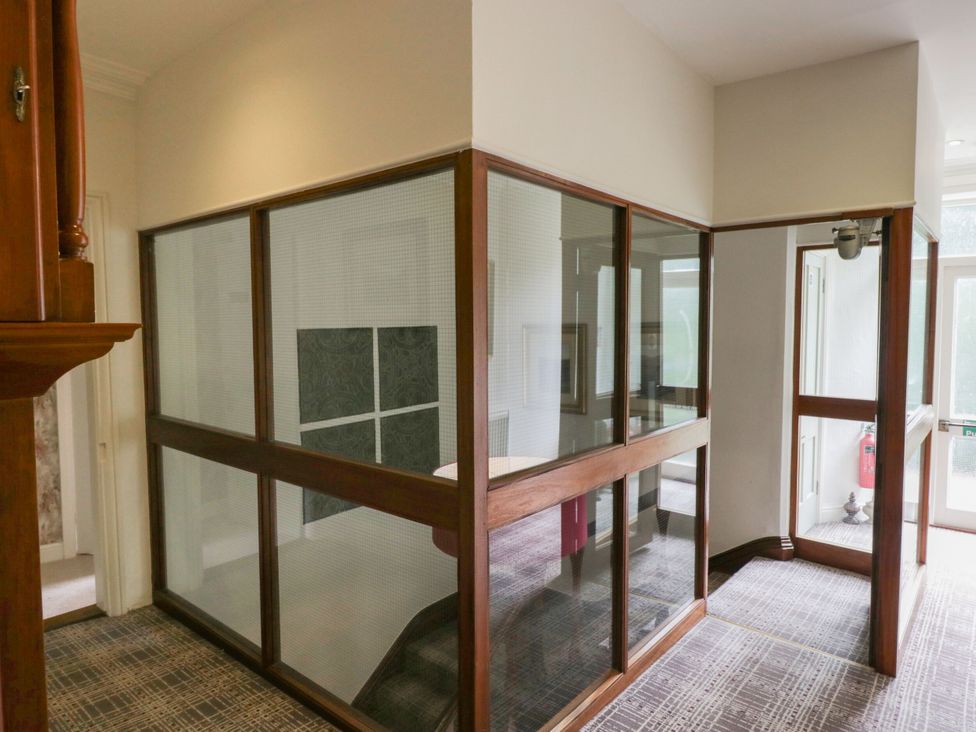 A hallway with glass walls and wooden frames at Coleridge in Ambleside