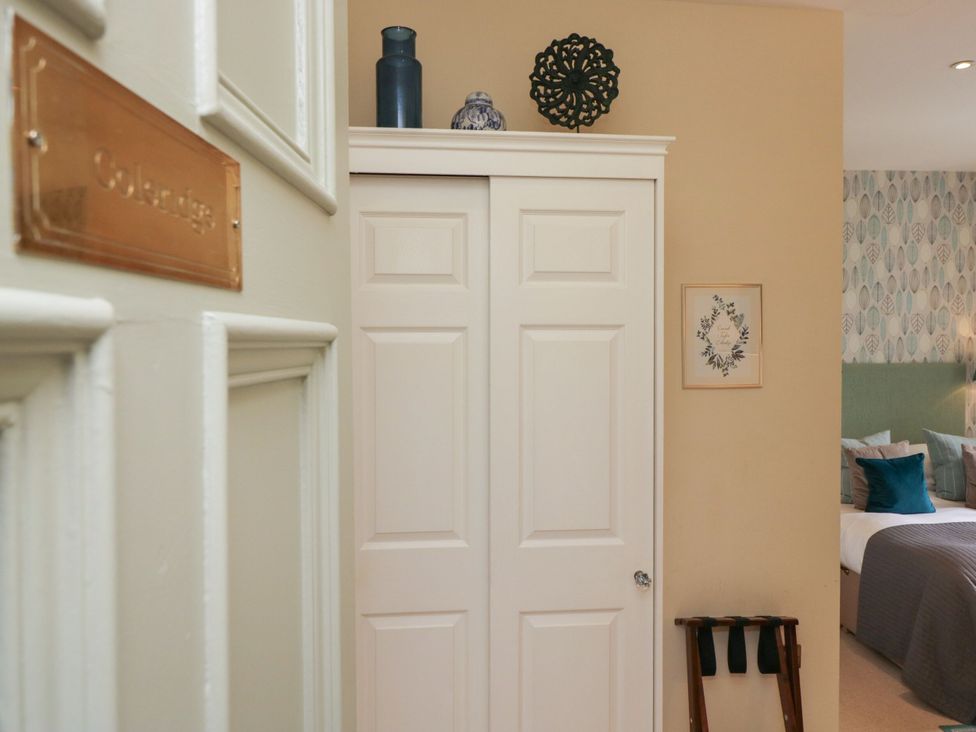 A bedroom with a closet and a decorative wall at Coleridge in Ambleside