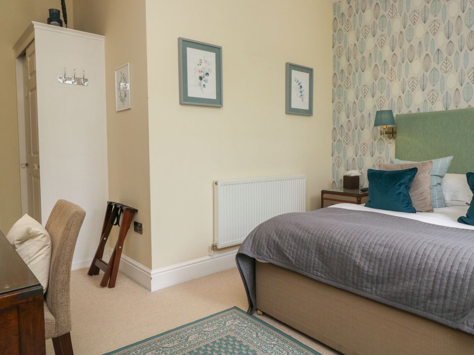 A bedroom with a bed and wardrobe at Coleridge in Ambleside