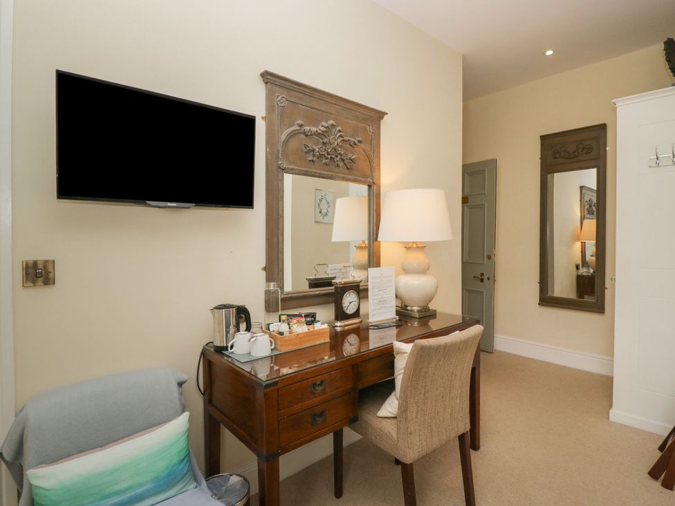 A bedroom with a desk and mirror at Coleridge in Ambleside