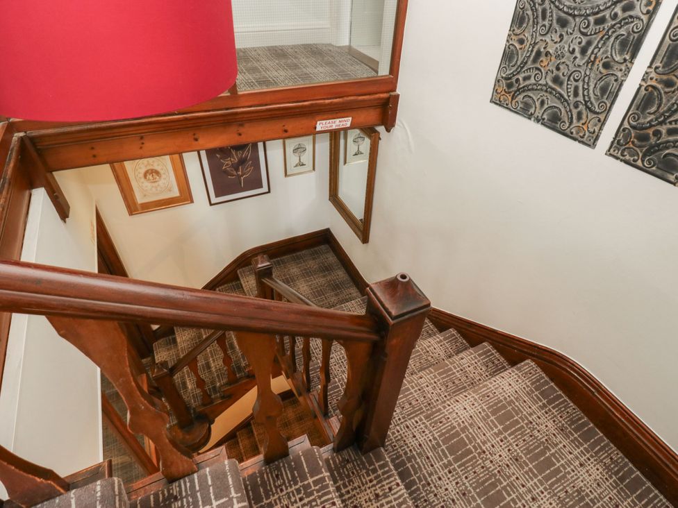 A staircase with a lamp and artwork on the walls at Coleridge in Ambleside