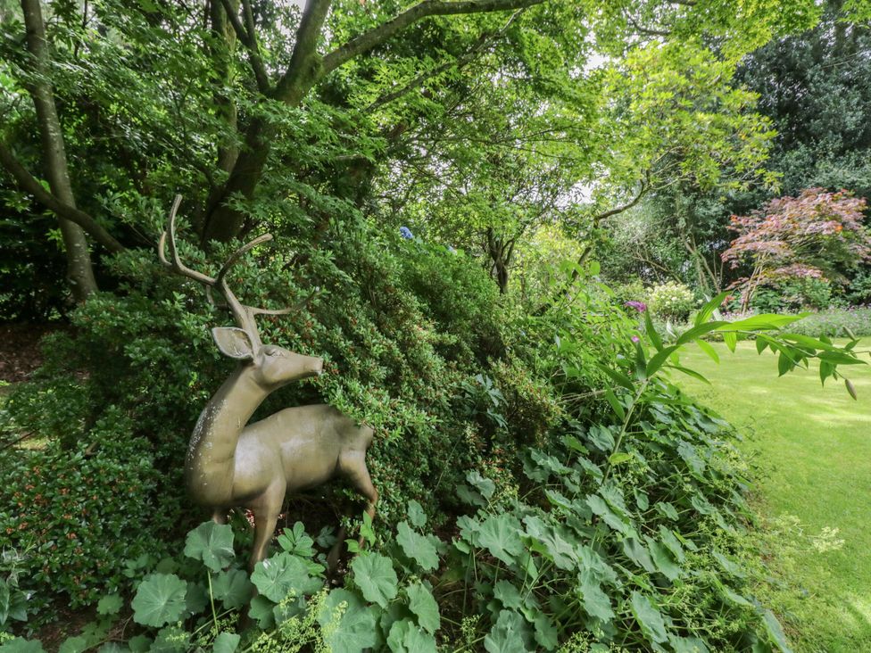 A deer statue among greenery at Coleridge in Ambleside