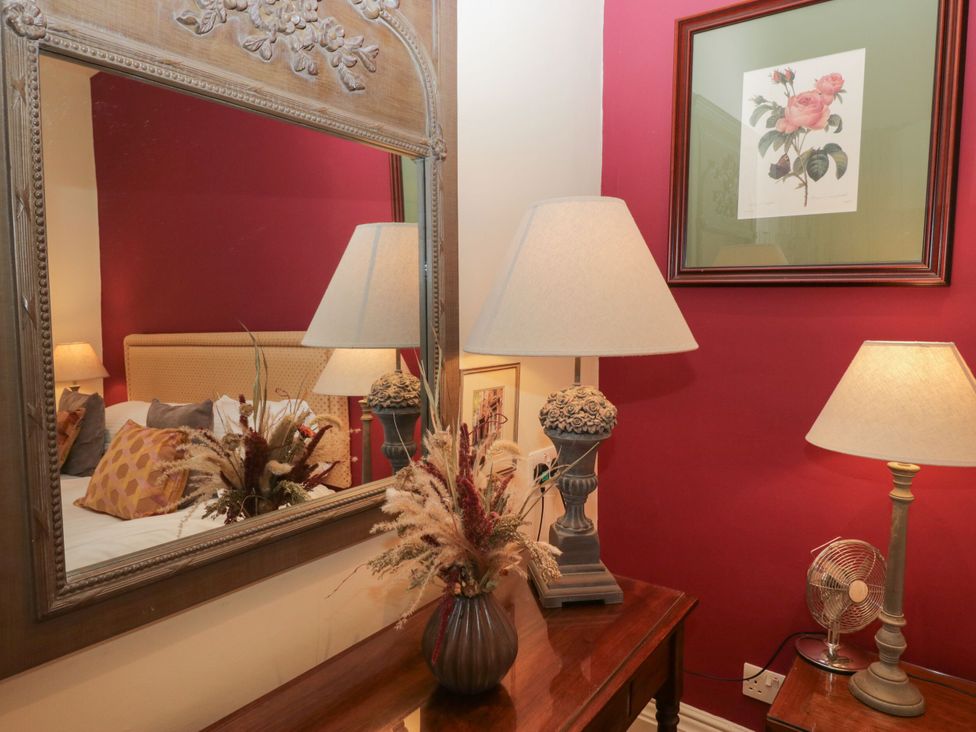 A bedroom with a mirror and lamps at Dorothy in Ambleside