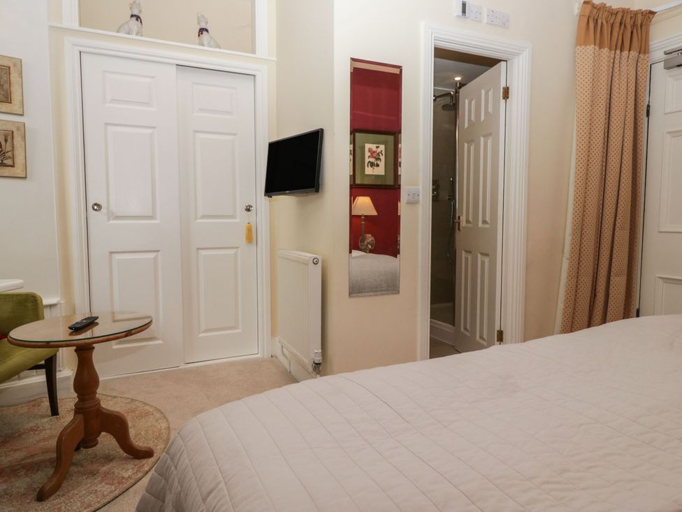 A bedroom with a bed, table, and TV at Dorothy in Ambleside