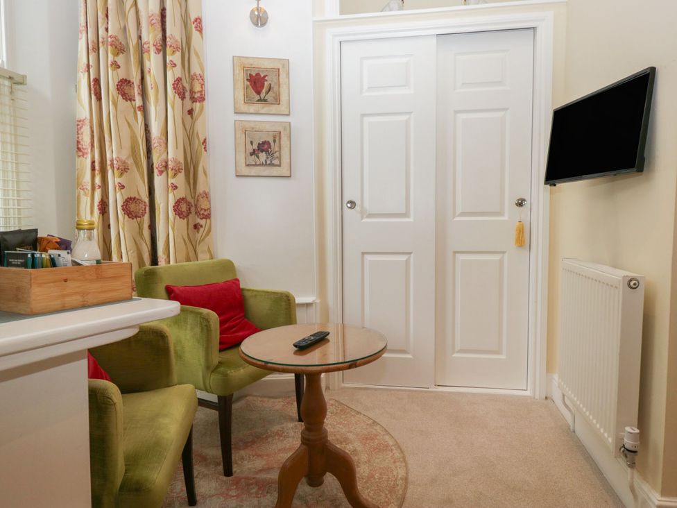 A snug area with a table and armchairs at Dorothy in Ambleside