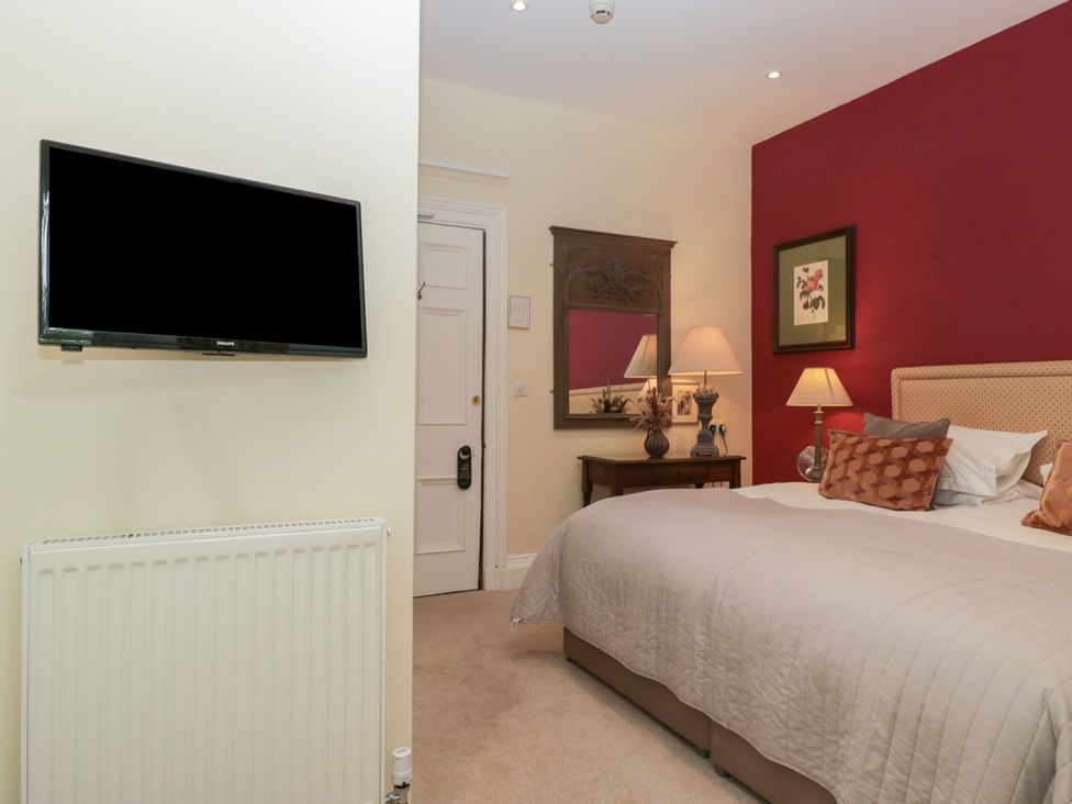 A bedroom with a bed, lamp, and TV at Dorothy in Ambleside