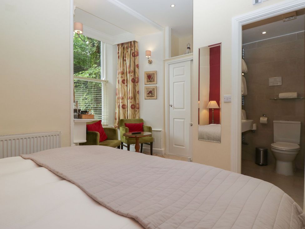 A bedroom with a bed and seating area at Dorothy in Ambleside