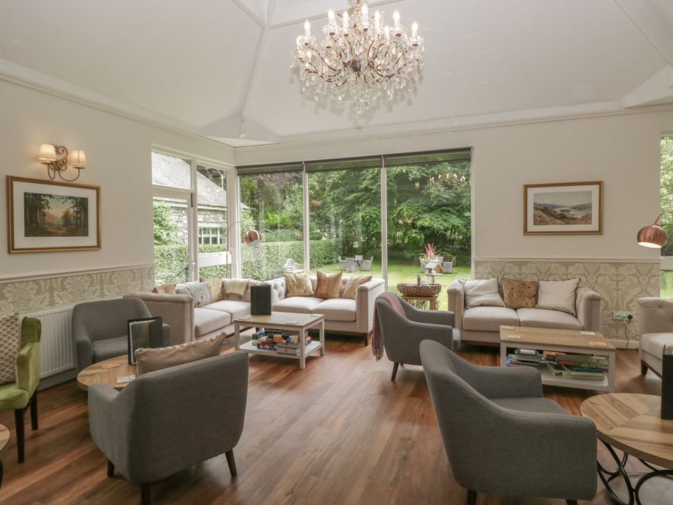 A living room with seating and natural light from large windows at Dorothy in Ambleside