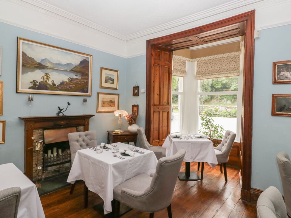 A dining room with tables and paintings at Dorothy in Ambleside
