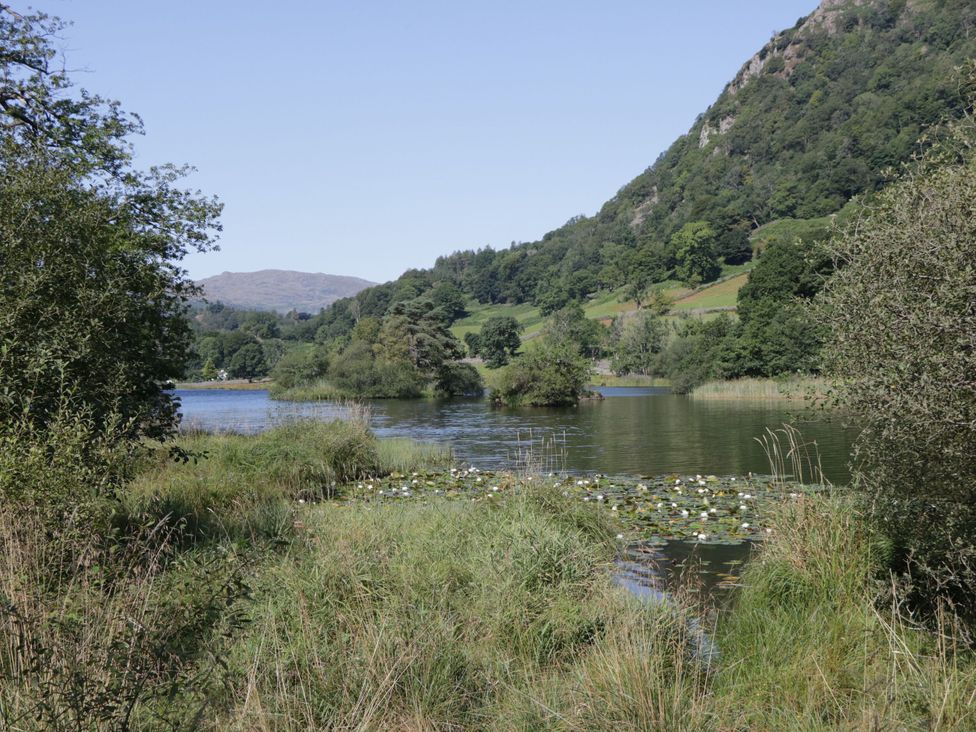 A lake surrounded by greenery and mountains at Dorothy in Ambleside
