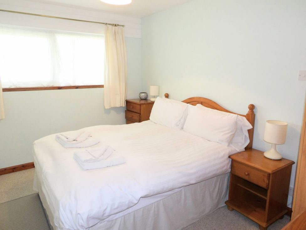 A bedroom with a double bed and nightstand at the property