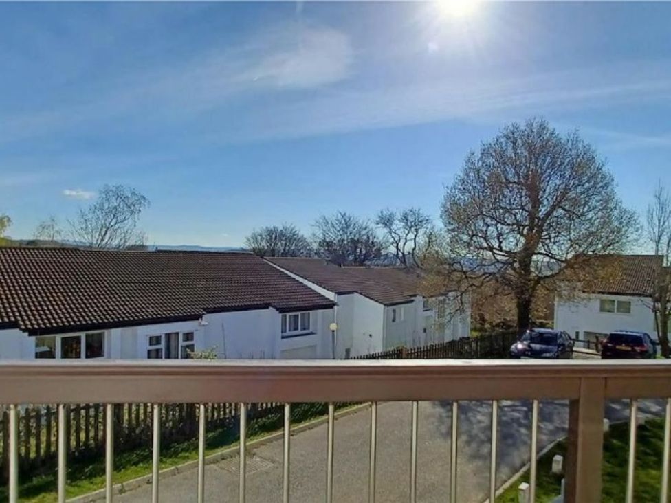 A view of houses and trees from a balcony at a property location