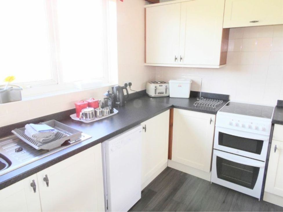 A kitchen with sink, dishwasher, kettle, toaster, and cooking appliances at The Old Barn in Manchester