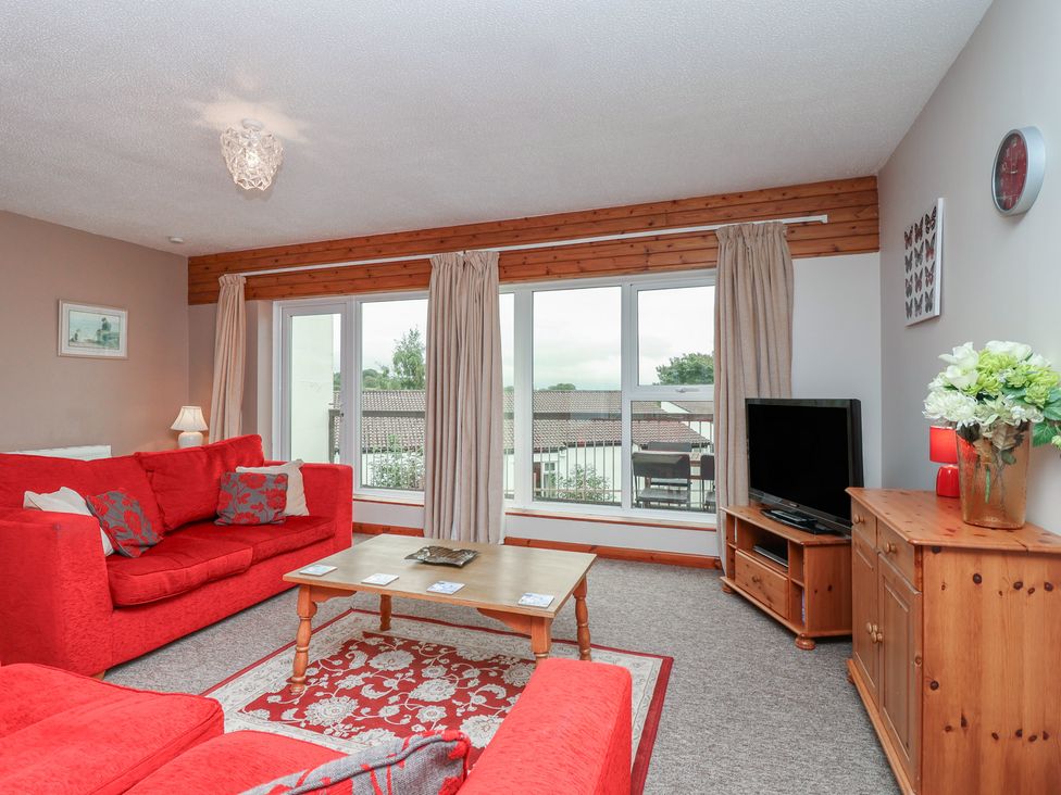 A living room with a sofa, coffee table and television at 21 Tamar & St. Anns Cottages Honicombe Park near St. Ann's Chapel, Cornwall