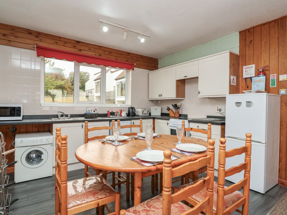A kitchen with a dining table and appliances at 21 Tamar & St. Anns Cottages Honicombe Park near St. Ann's Chapel, Cornwall