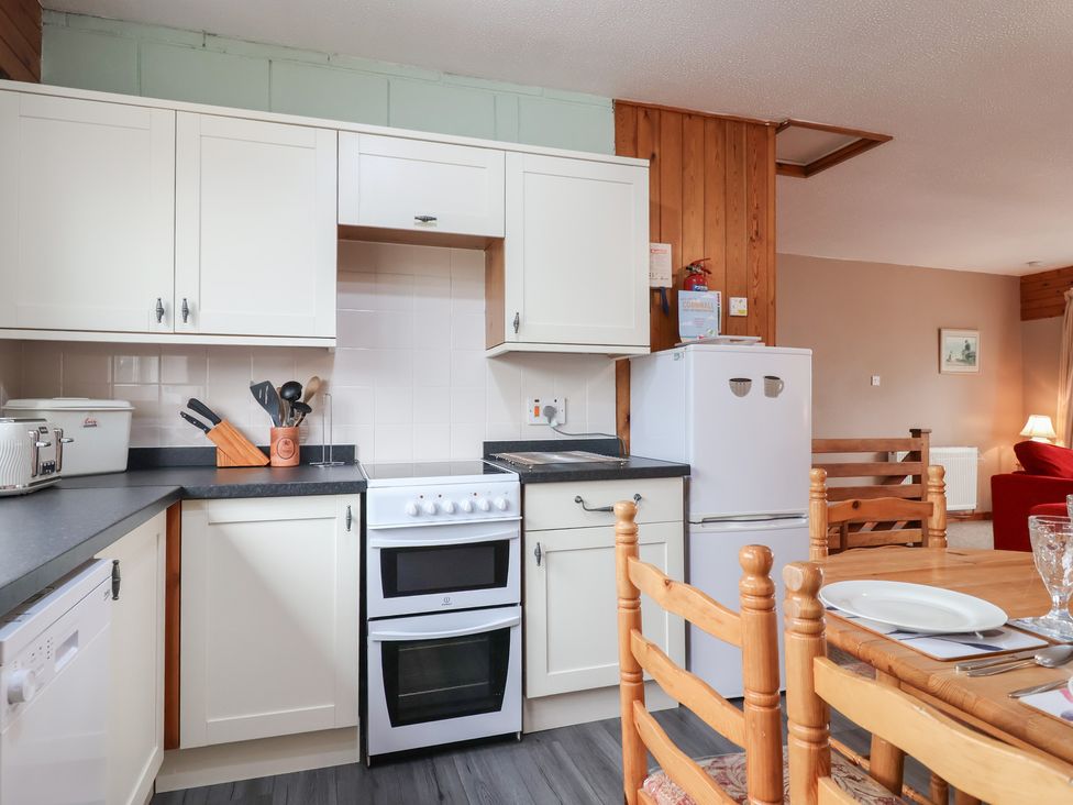 A kitchen with cooking appliances and dining table at 21 Tamar & St. Anns Cottages Honicombe Park near St. Ann's Chapel, Cornwall