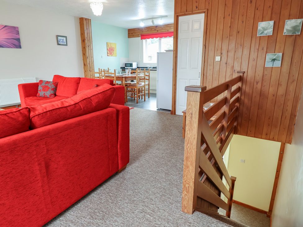 A living room with a sofa and dining area at 21 Tamar & St. Anns Cottages, Honicombe Park near St. Ann's Chapel, Cornwall