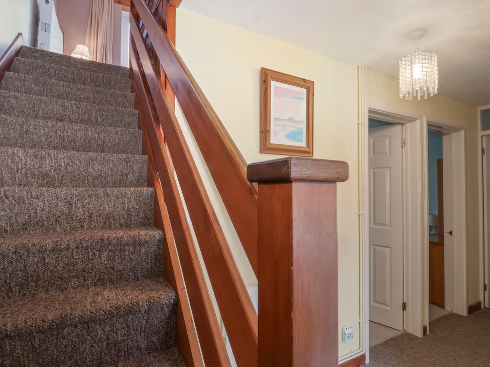 A staircase with wooden railing in a hallway at 21 Tamar & St. Anns Cottages, Honicombe Park near St. Ann's Chapel, Cornwall