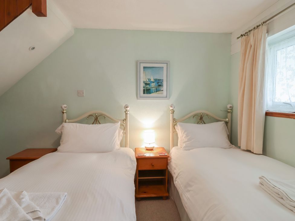 A bedroom with two beds and a lamp at 21 Tamar & St. Anns Cottages Honicombe Park near St. Ann's Chapel, Cornwall