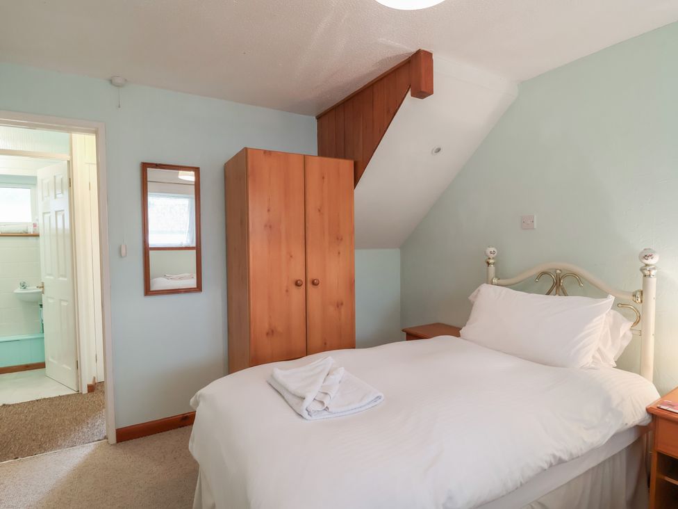 A bedroom with a bed and wardrobe at 21 Tamar & St. Anns Cottages in Honicombe Park near St. Ann's Chapel, Cornwall