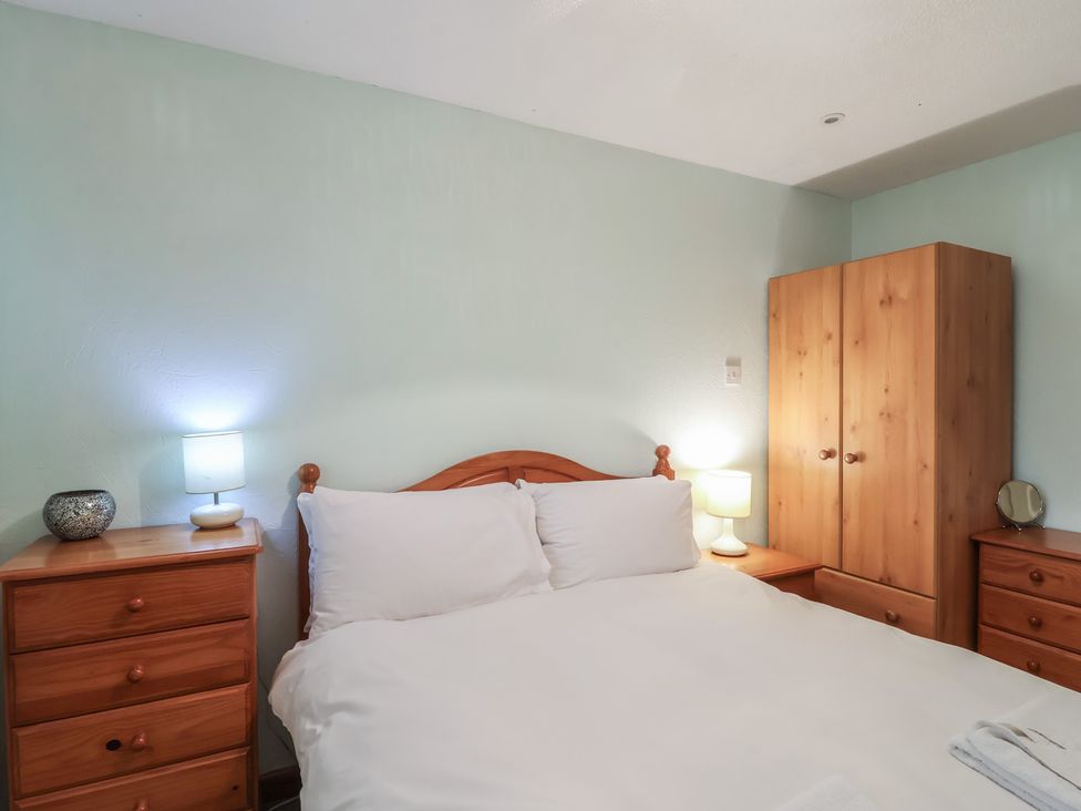 A bedroom with a bed and furniture at 21 Tamar & St. Anns Cottages, Honicombe Park near St. Ann's Chapel, Cornwall