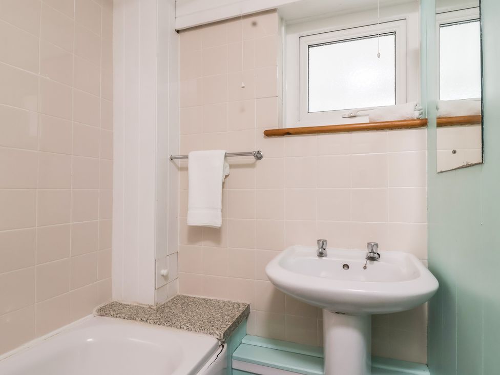 A bathroom with a bathtub and a sink at 21 Tamar & St. Anns Cottages, Honicombe Park near St. Ann's Chapel, Cornwall
