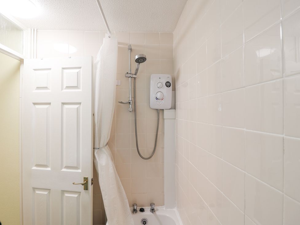 A bathroom with a shower and a bath at 21 Tamar & St. Anns Cottages Honicombe Park near St. Ann's Chapel, Cornwall