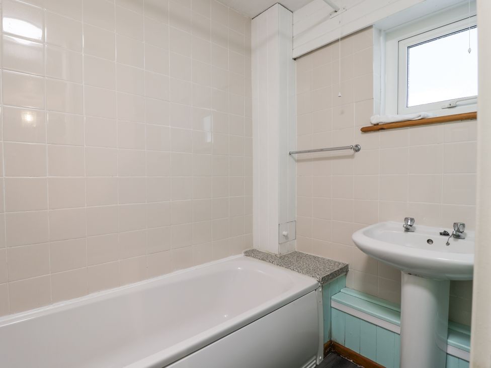 A bathroom with a bathtub and sink at 21 Tamar & St. Anns Cottages Honicombe Park near St. Ann's Chapel, Cornwall