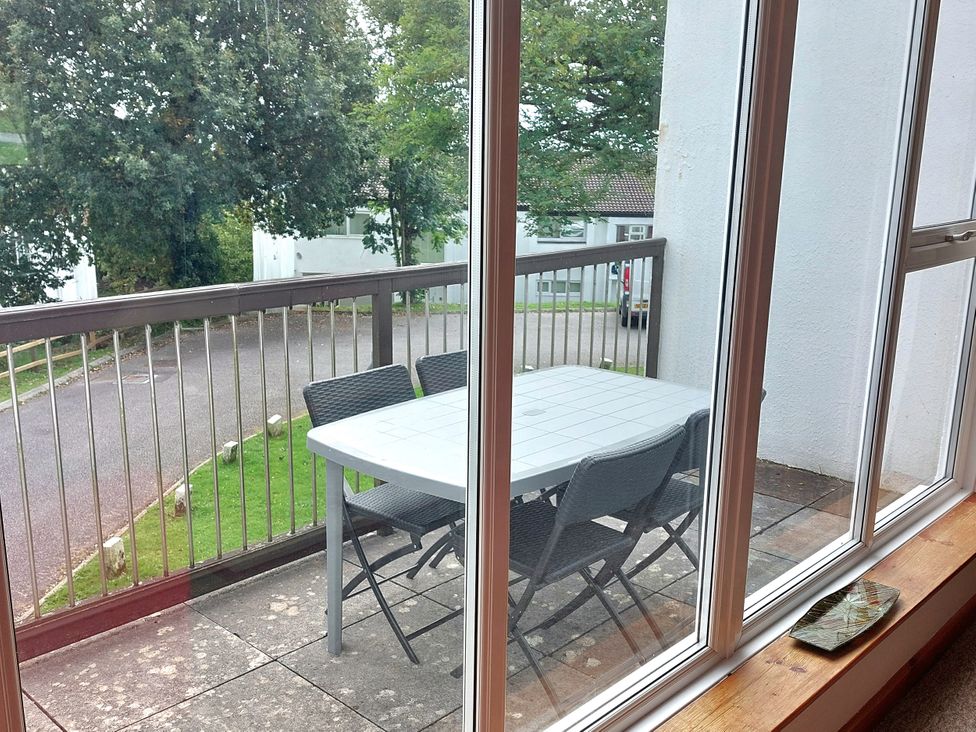 A balcony with a table and chairs at 21 Tamar & St. Anns Cottages Honicombe Park near St. Ann's Chapel, Cornwall
