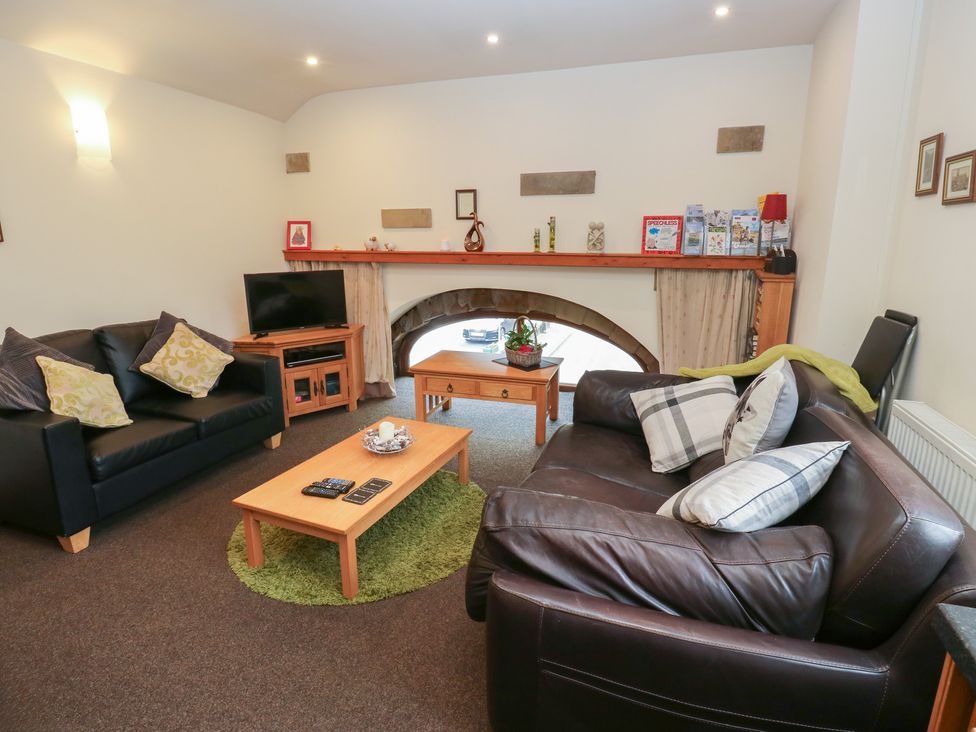 A living room with a television and wooden table at Green Route Apartment