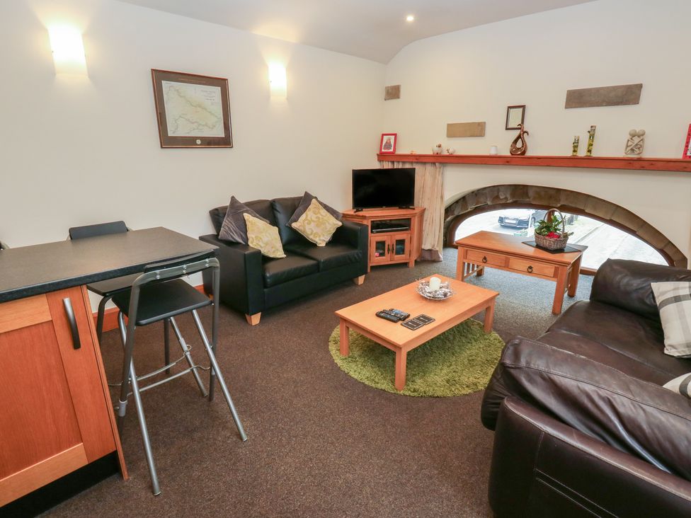 A living room with a coffee table and sofa at Green Route Apartment