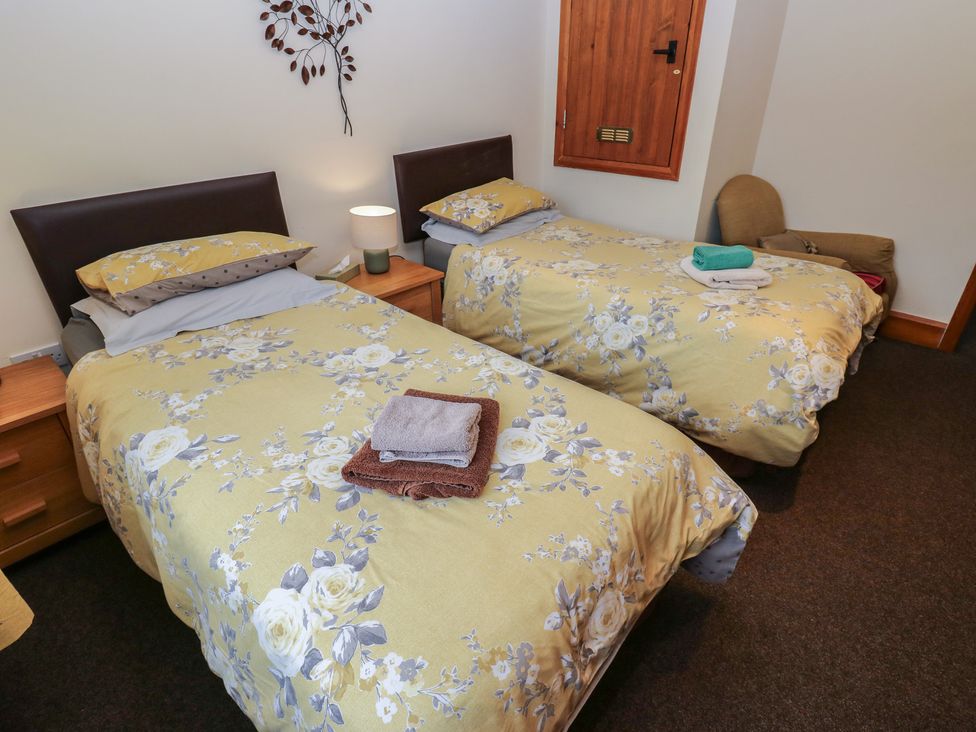 A bedroom with two beds and a nightstand at Green Route Apartment