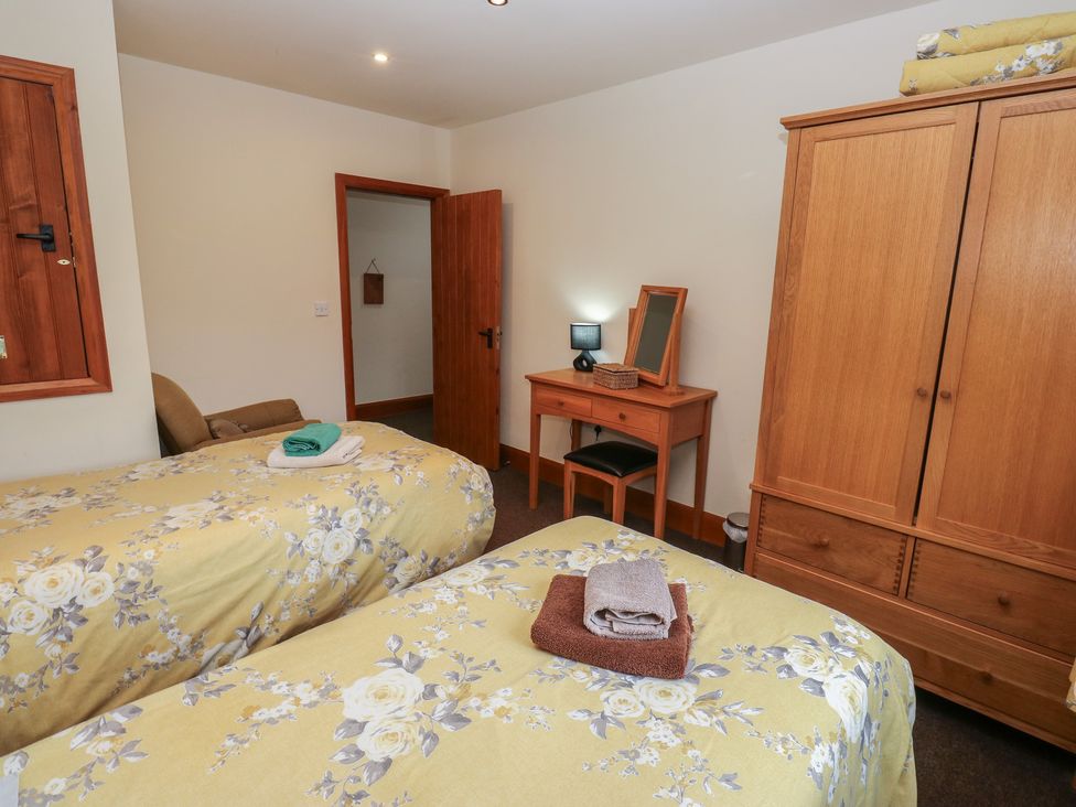 A bedroom with two beds and a dressing table at Green Route Apartment