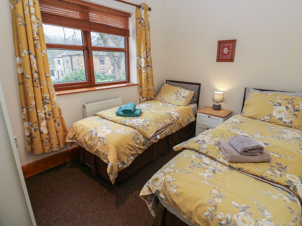 A bedroom with two beds and a window at Green Route Apartment
