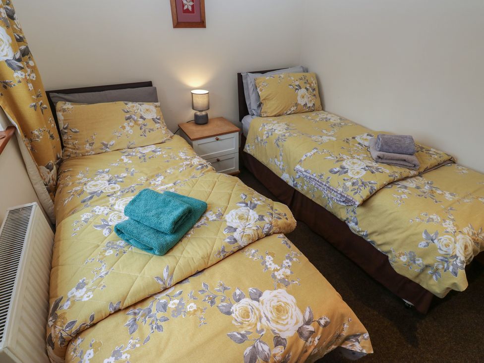A bedroom with two beds and a bedside table at Green Route Apartment