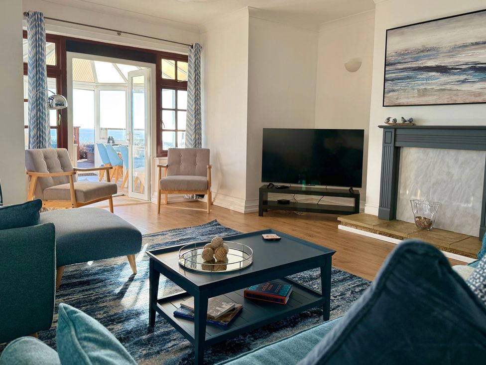 A living room with a sofa and a television at Crows Nest Dawlish