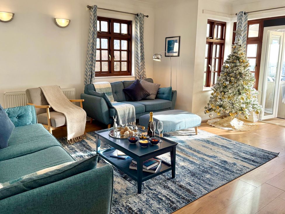 A living room with a coffee table and a decorative tree at Crows Nest Dawlish