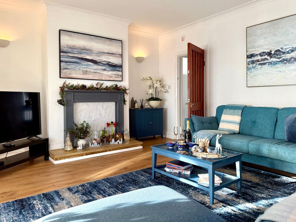 A living room with a sofa and a television at Crows Nest Dawlish