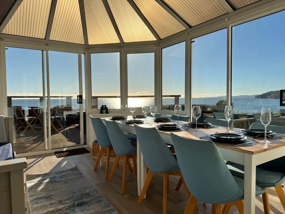 A dining area with a view of the sea at Crows Nest Dawlish