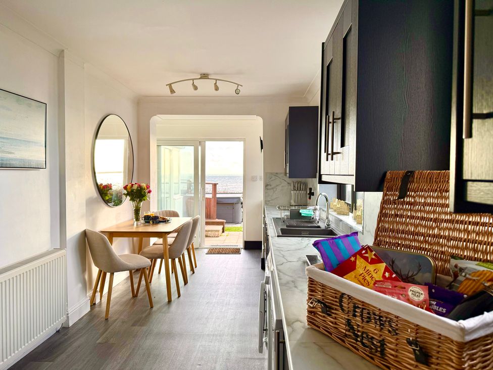 A kitchen with a table and chairs at Crows Nest Dawlish