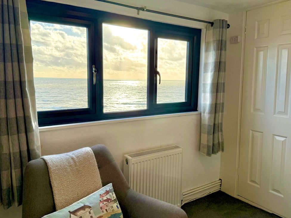 A living room with a window facing the ocean at Crows Nest Dawlish